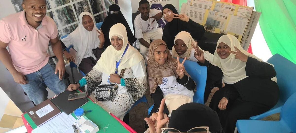 Students and mentors celebrating at the Lamu Tech Hub stand