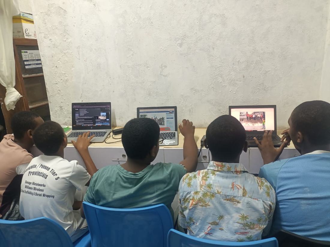 Students exploring the internet on laptops at the hub